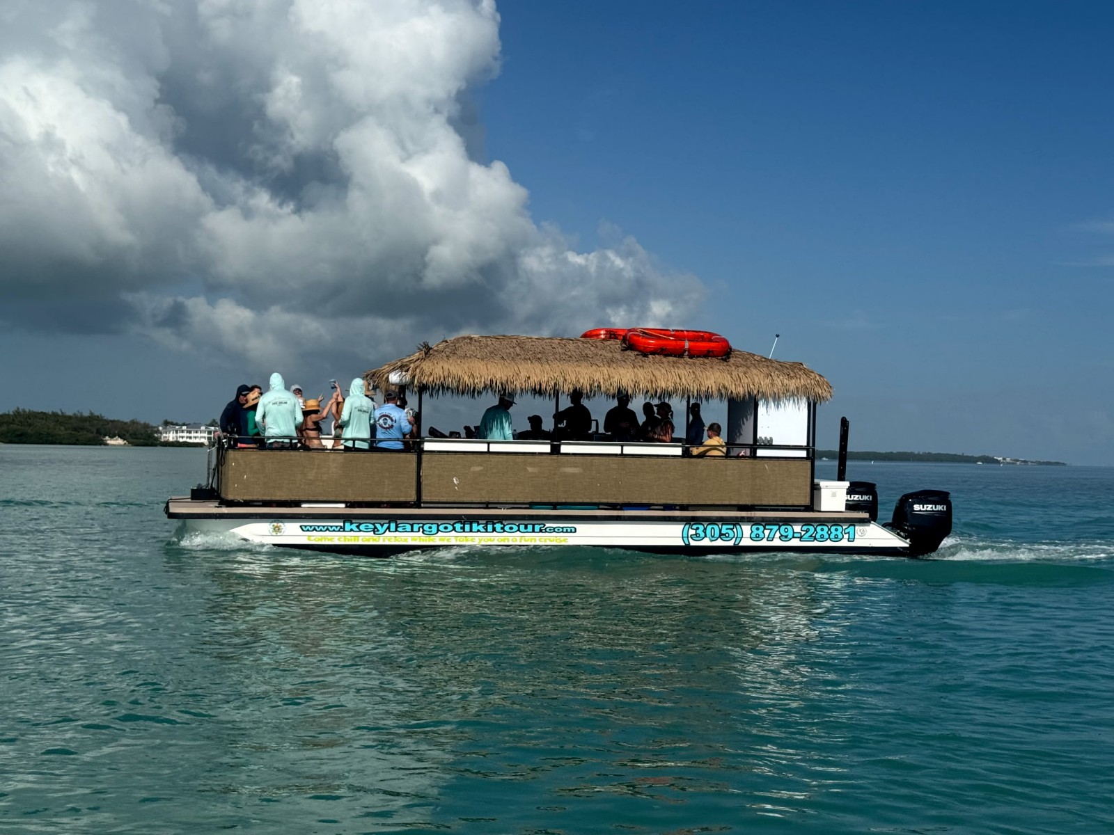 A tiki boat on the water with the text "Key Largo Book Private Charters"