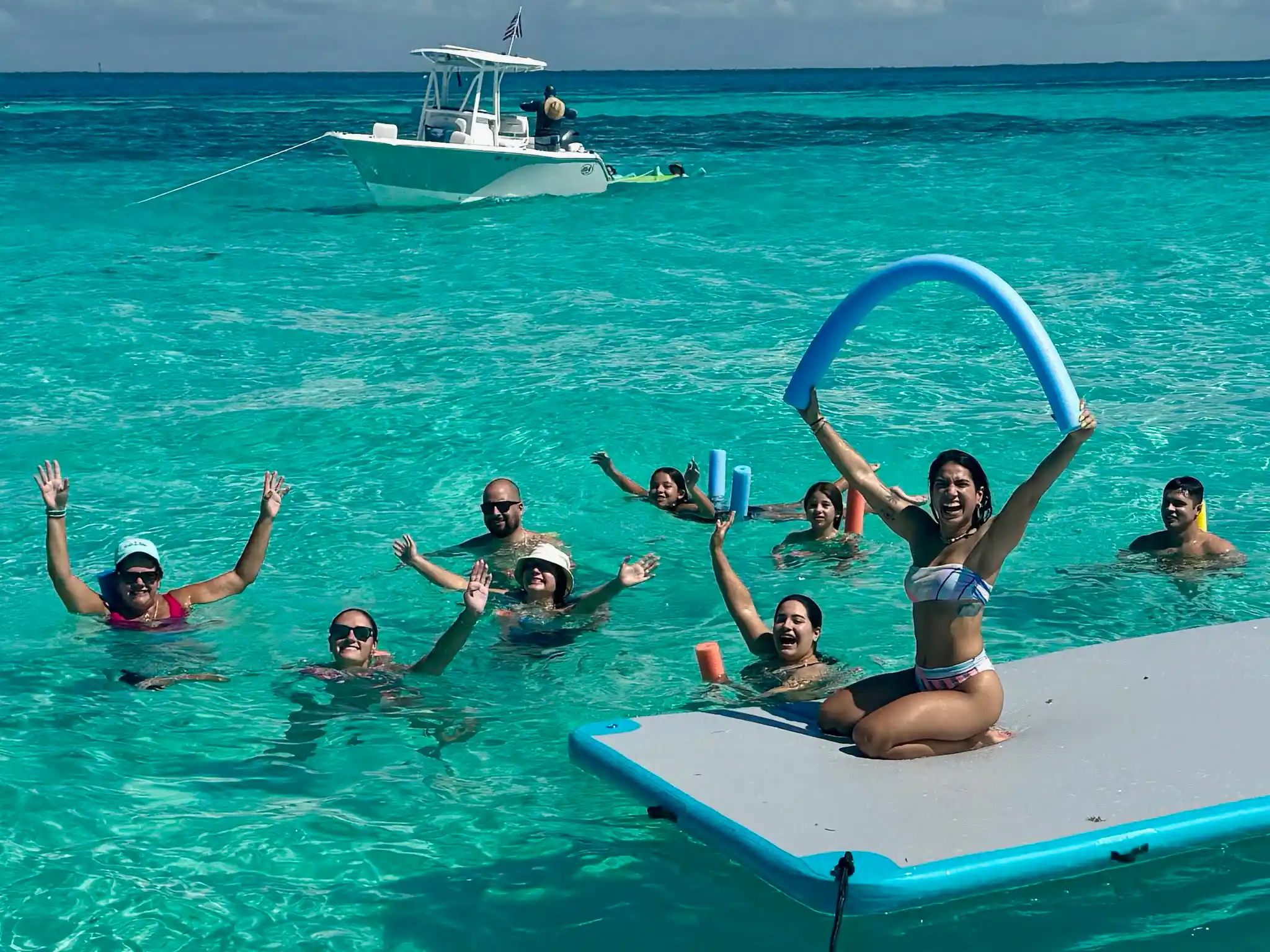 A group of people swimming and enjoying boat cruise a Florida Keys Tiki Tours .
