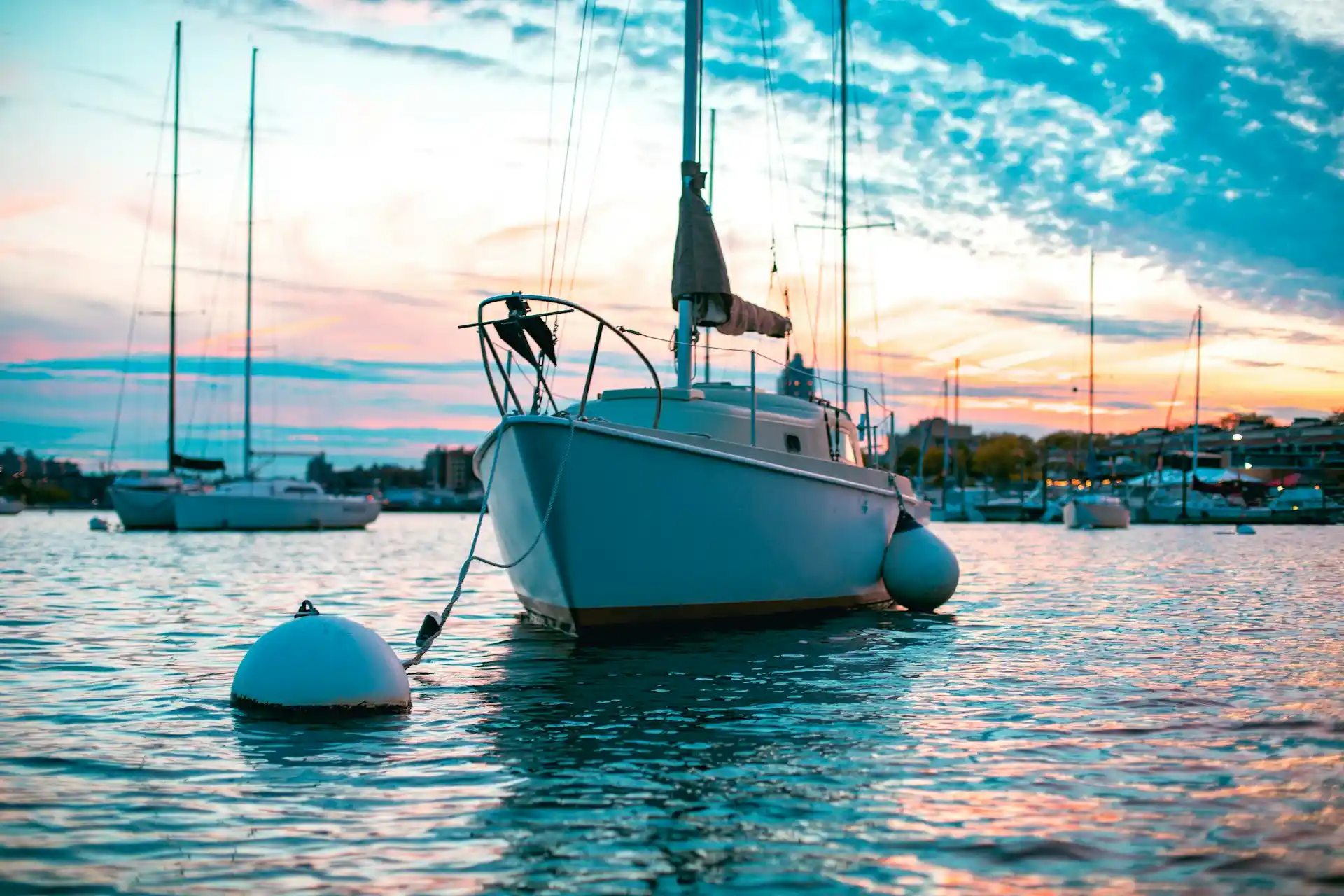 Sailboats and other vessels anchored in a marina at sunset, typical of Florida's waterfronts, prompting inquiry into how much do boat rentals cost in Florida.